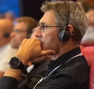 Participant à l'écoute attentive d'une traduction simultanée au casque