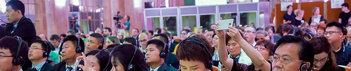 Participants suivant une conférence multilingue au Salon Hoche à Paris